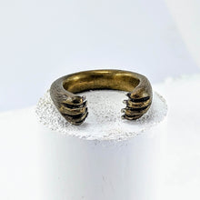 Load image into Gallery viewer, The Bear Hug Ring by NZ jeweller Vaune Mason has two bear paws encircling your finger. The Ring is made in warm bronze and the claws are sterling silver.