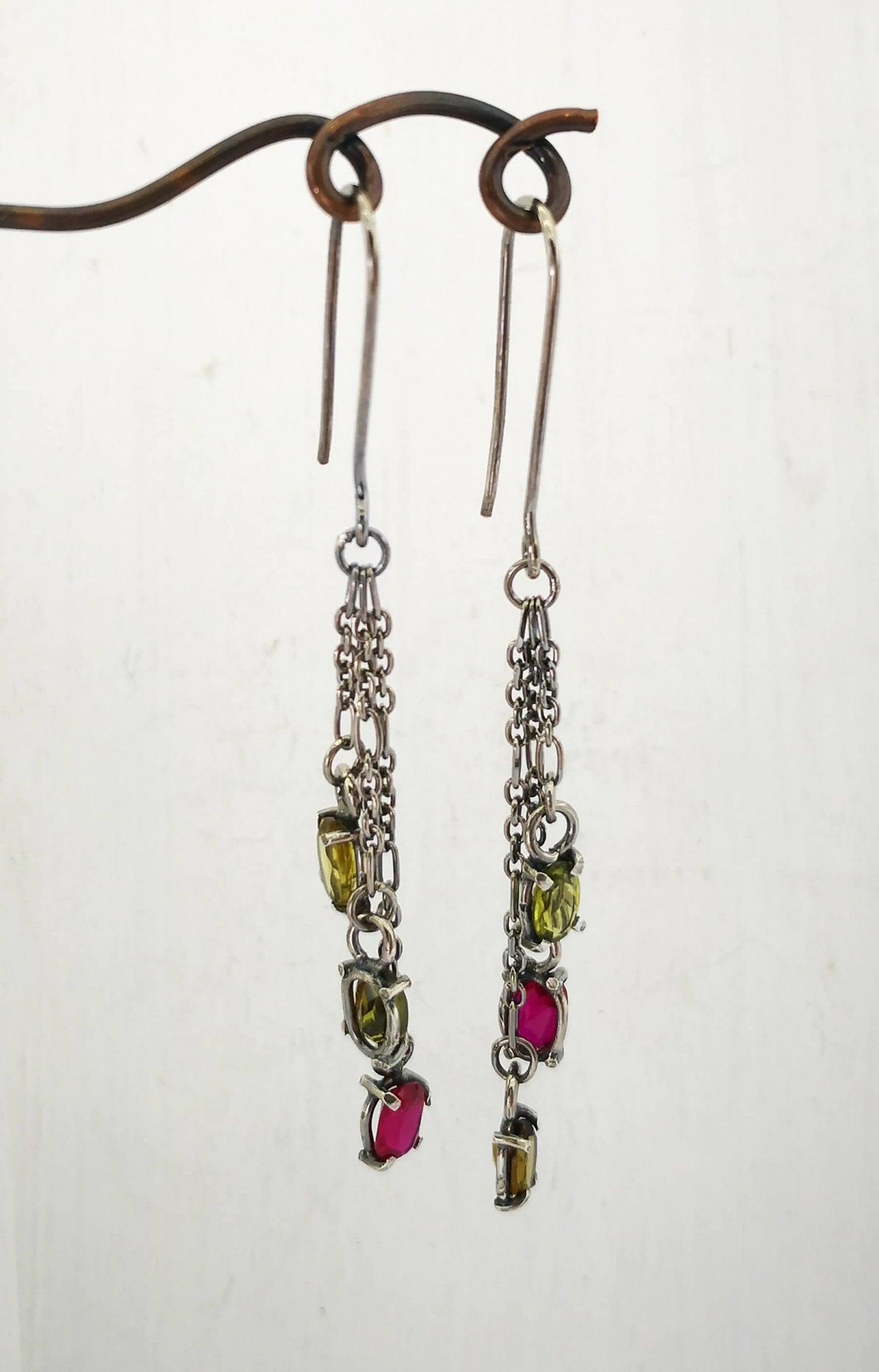 These gem cluster earrings hold olive green tourmaline and pink lab sapphires in small silver settings. Hand crafted by Vaune Mason.