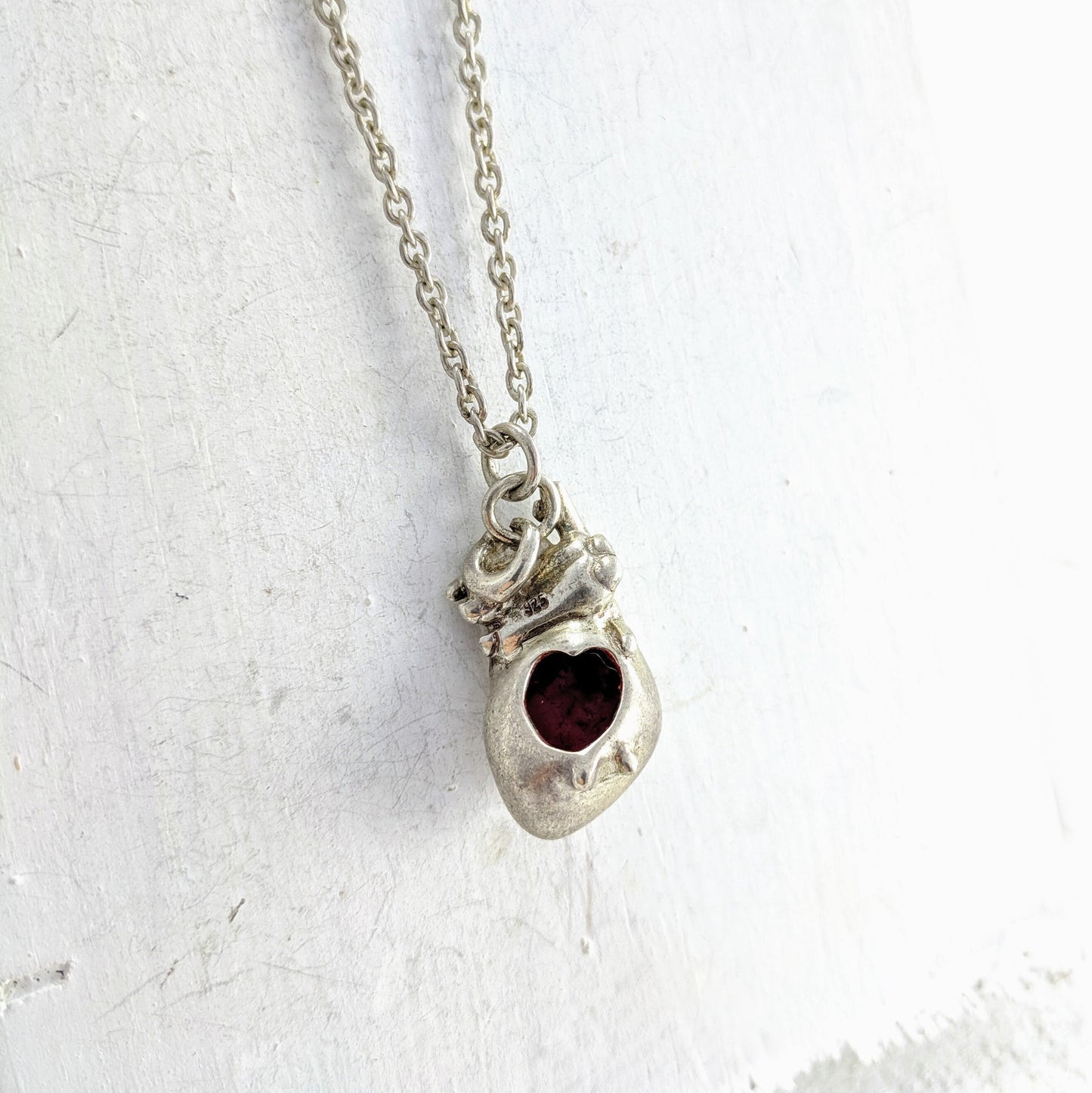 Handmade in New Zealand, this is a silver necklace with an anatomical heart pendant and red enamel detailing.