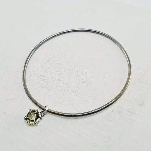 A slender bracelet in oxidised silver and 9ct gold with a golden quartz charm. Hand crafted NZ jewellery by Natalie Salisbury. Available at Mason and Collins. 
