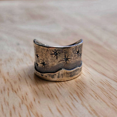 The Matariki Maunga Ring is a wide tapered band hand crafted in solid sterling silver by Buster Collins. Quality NZ silver jewellery available at Mason and Collins.