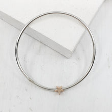 Load image into Gallery viewer, This sleek bracelet is hand-crafted in round sterling silver bar with a solid rose gold star charm. Available now at Mason and Collins. 
