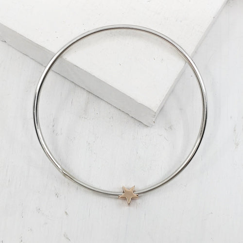 This sleek bracelet is hand-crafted in round sterling silver bar with a solid rose gold star charm. Available now at Mason and Collins. 