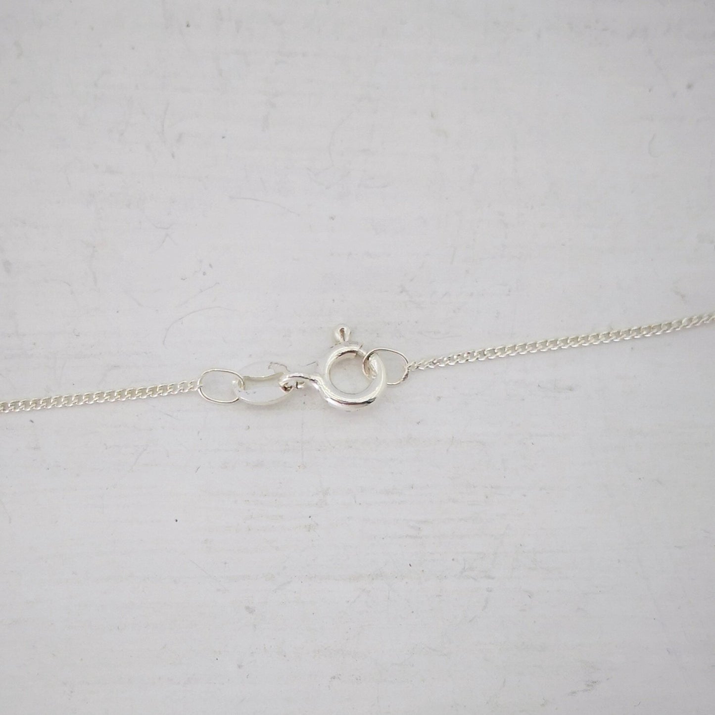 Close up of the small silver bolt-catch on the Ruru Pendant. From Ruru Jewellery.