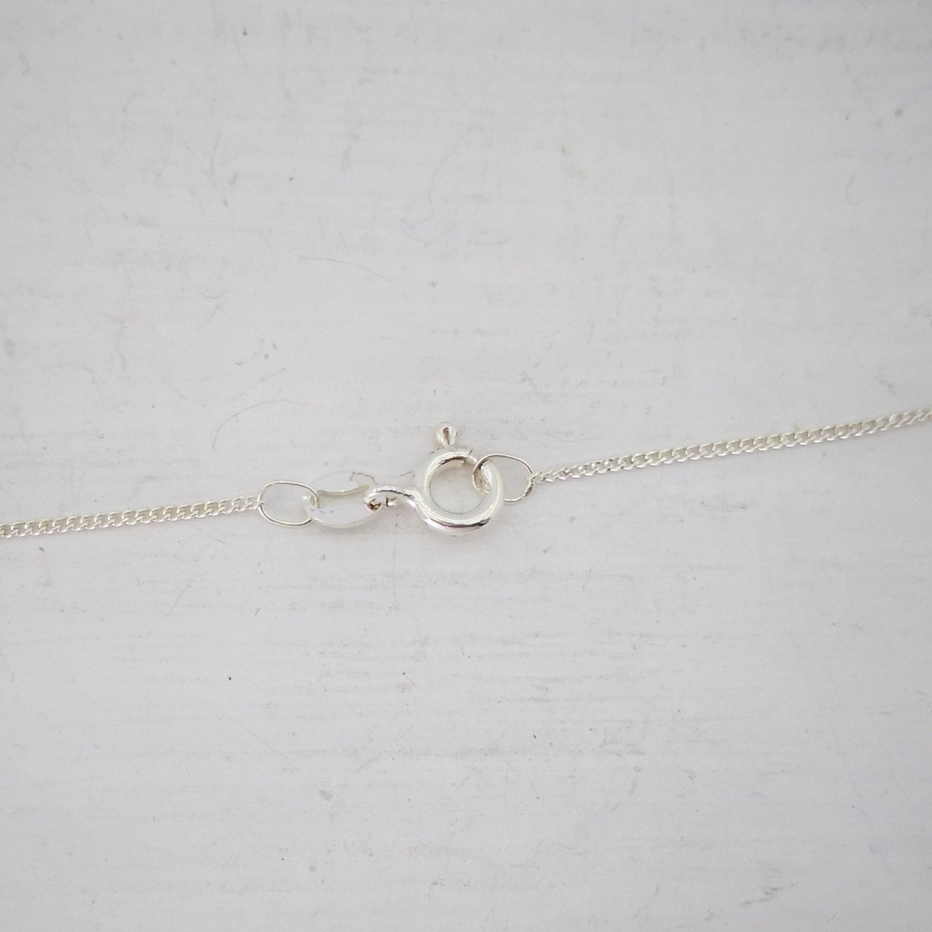 Close up of the small silver bolt-catch on the Ruru Pendant. From Ruru Jewellery.