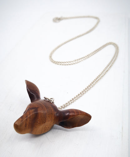 The Doe's Head Necklace is hand carved in richly coloured cherry wood, finished with oils and beeswax and hung on a long solid sterling silver chain. Crafted by NZ jeweller Vaune Mason.