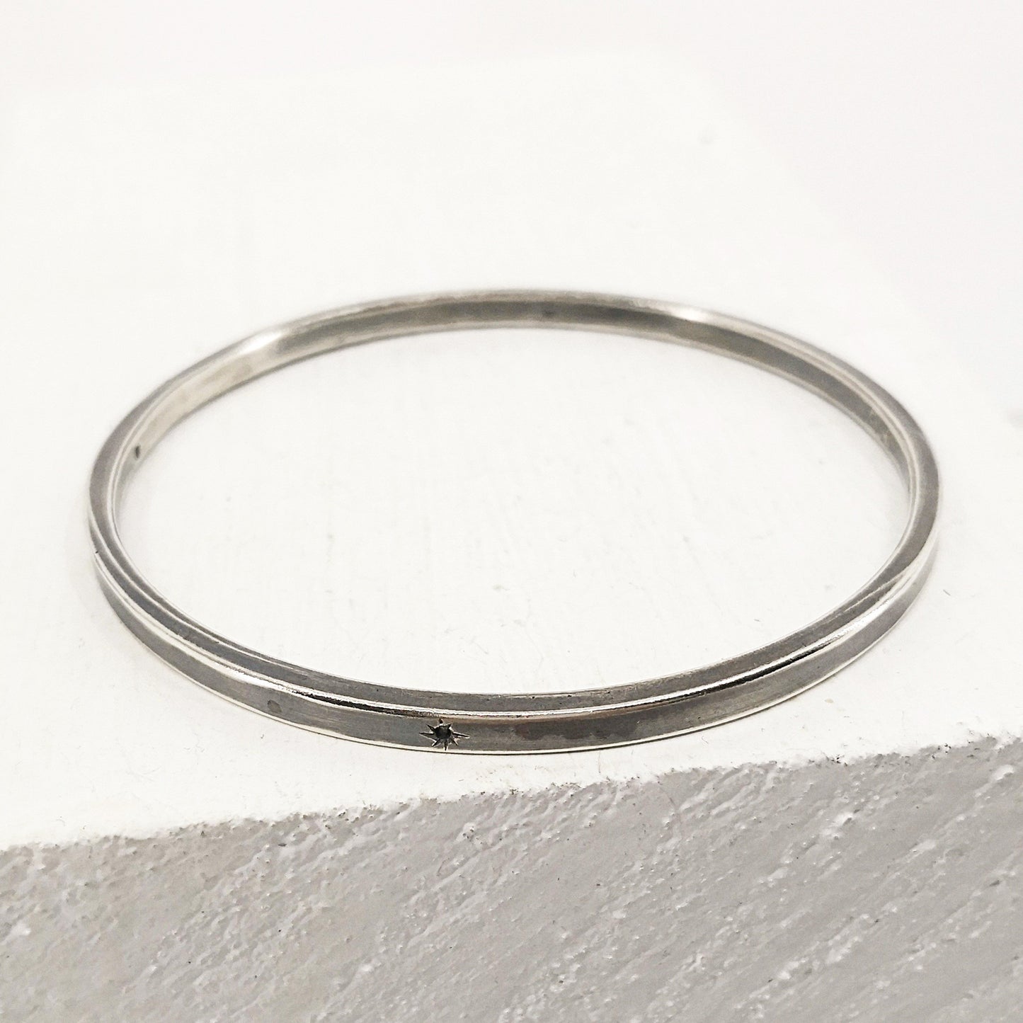 The Matariki Bangle in sterling silver, hand crafted in NZ by Buster Collins.