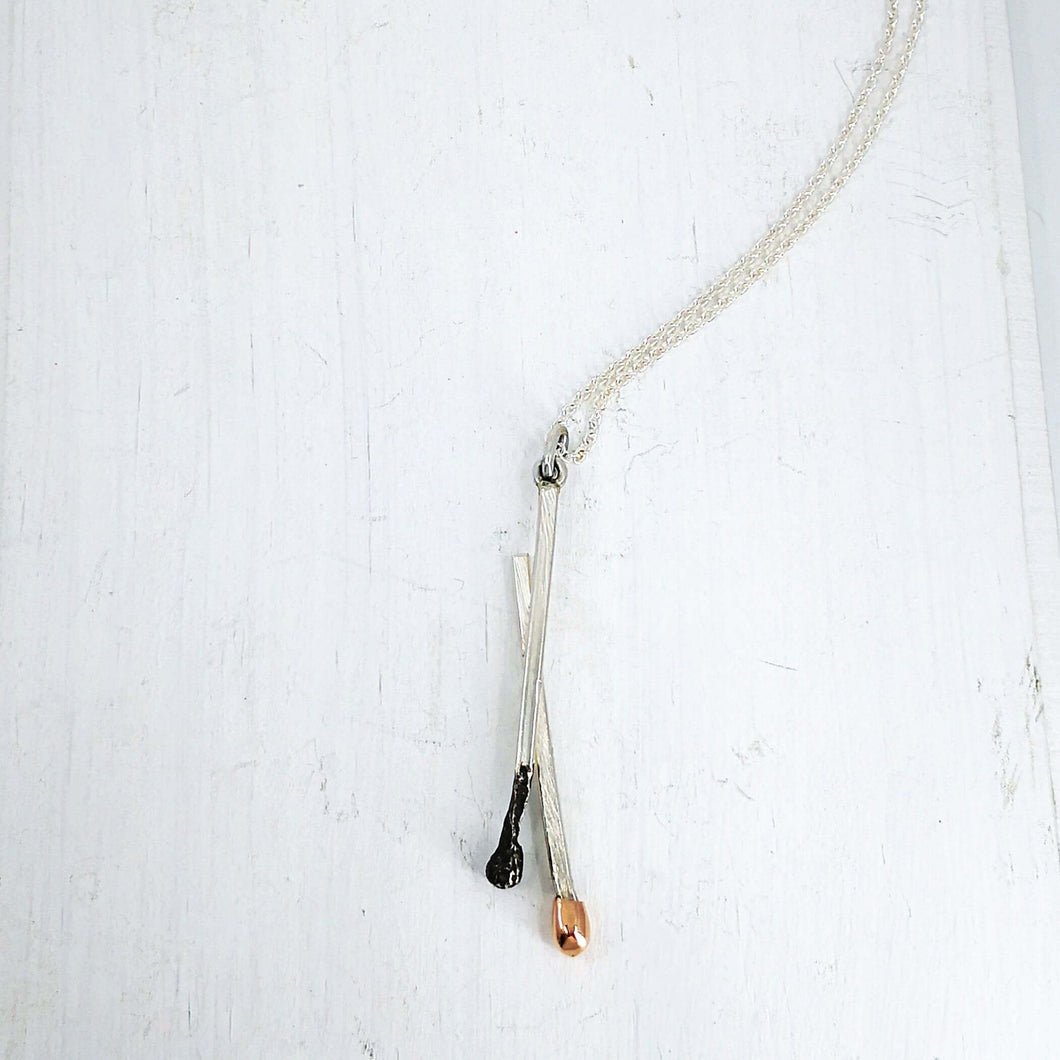 The Match Stick series pendant with burnt and live matches made from sterling silver and gold by David McLeod.