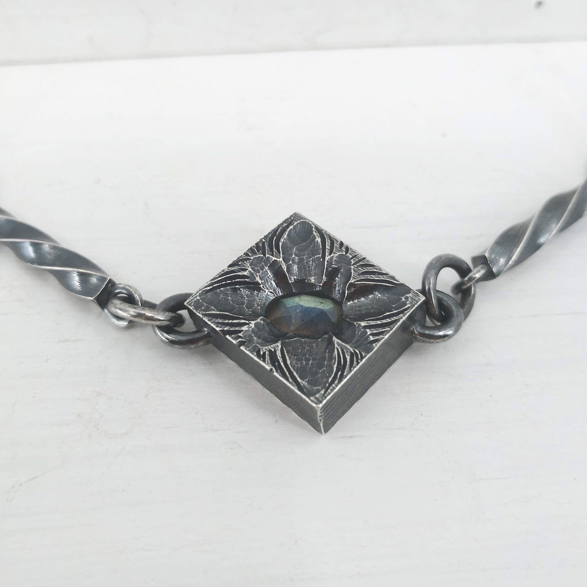 This statement necklace handcrafted by NZ jeweller Vaune Mason features hand-twisted silver chain links and a one-of-a-kind setting.