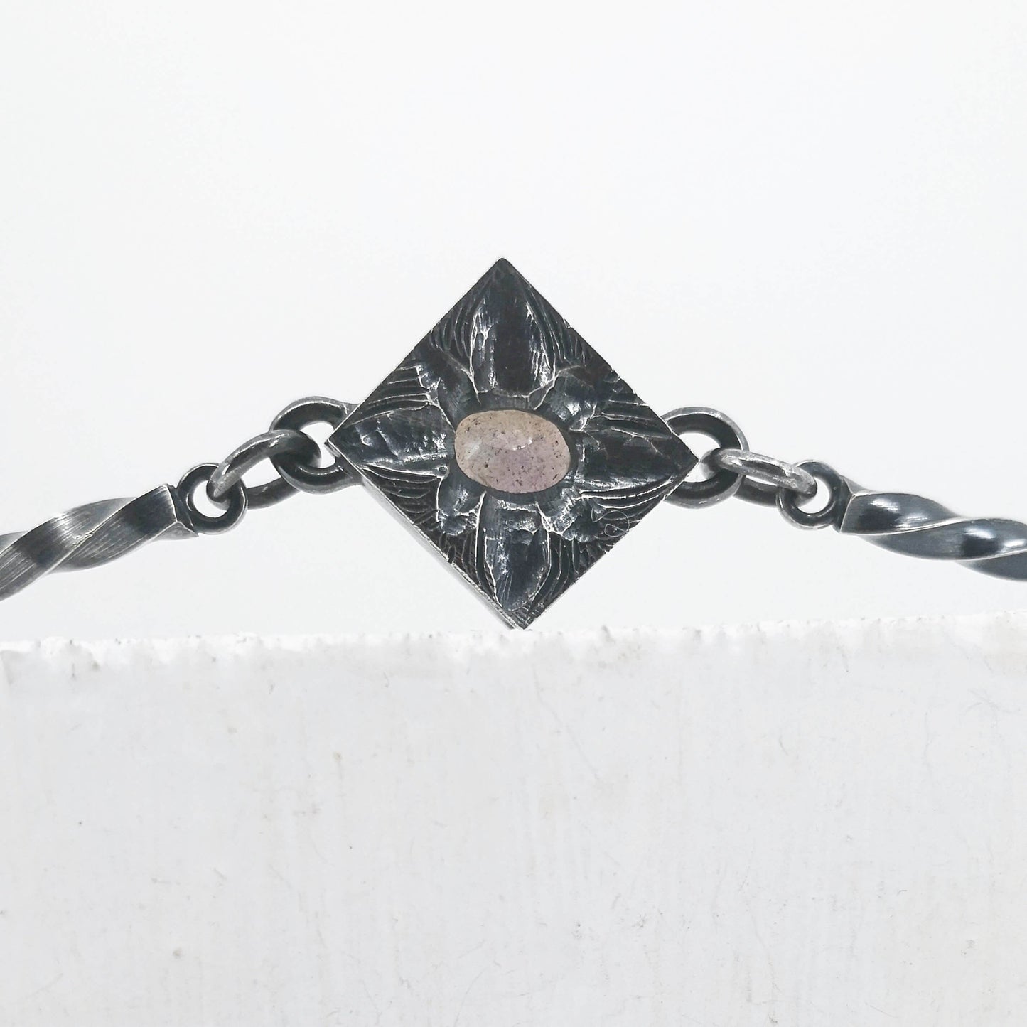 This statement necklace handcrafted by NZ jeweller Vaune Mason features hand-twisted silver chain links and a one-of-a-kind setting.