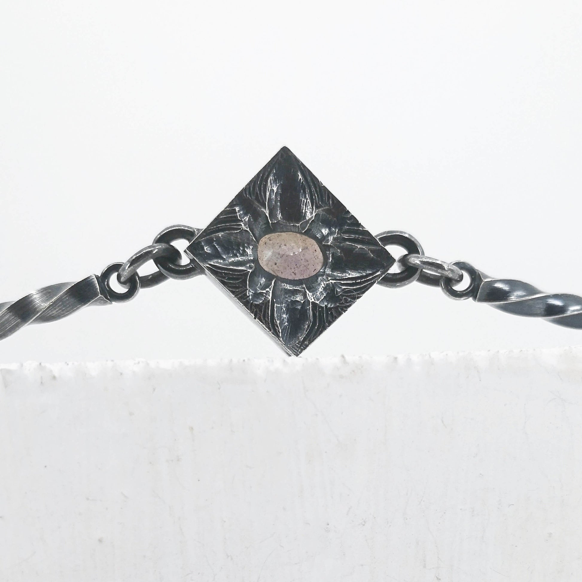 This statement necklace handcrafted by NZ jeweller Vaune Mason features hand-twisted silver chain links and a one-of-a-kind setting.