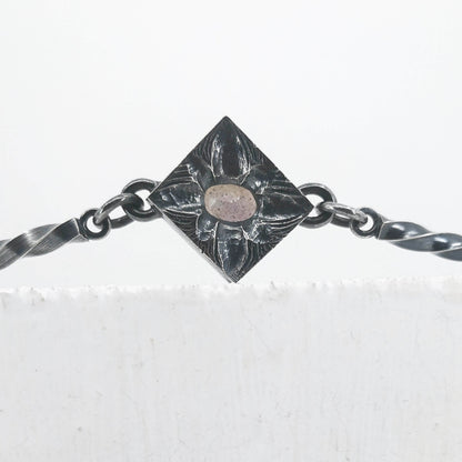 This statement necklace handcrafted by NZ jeweller Vaune Mason features hand-twisted silver chain links and a one-of-a-kind setting.