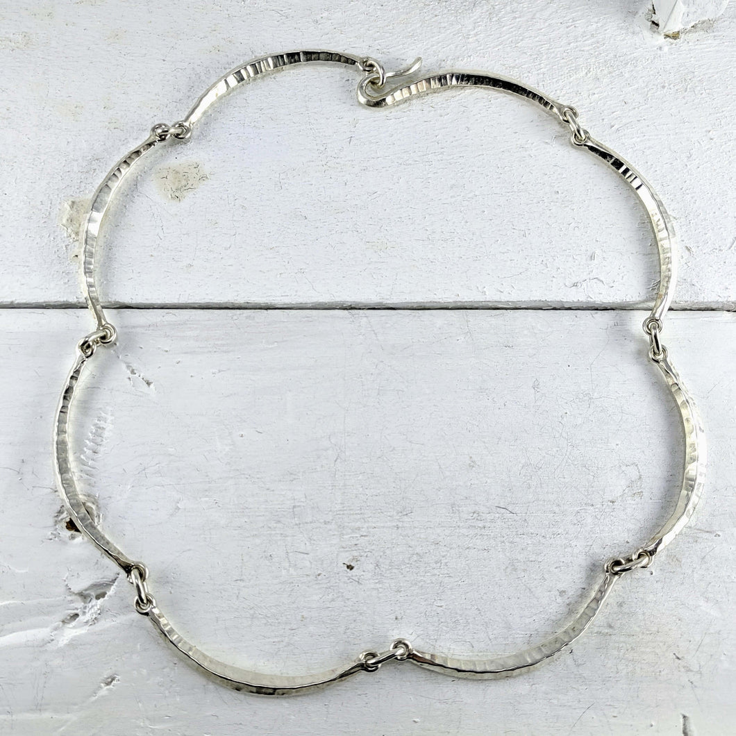 The forged scallop necklace is hand crafted by Dunedin based jeweller David McLeod. 