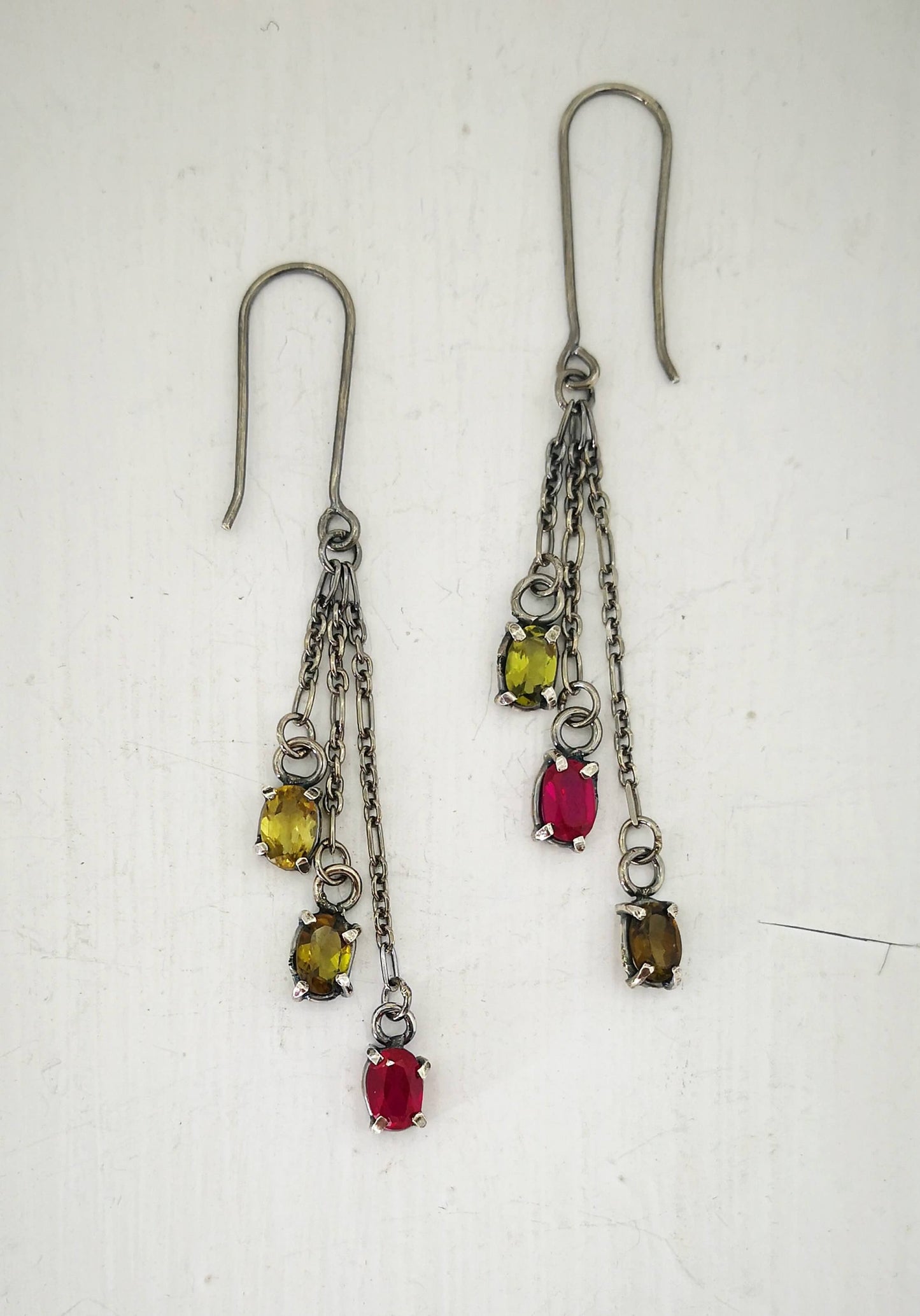 These gem cluster earrings hold olive green tourmaline and pink lab sapphires in small silver settings. Hand crafted by Vaune Mason.