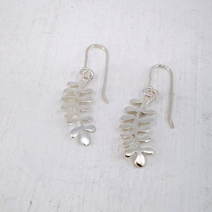 These light silver earrings are hand crafted in the shape of the NZ native Kowhai leaf. Made by Ruru Jewellery and available at Mason and Collins.