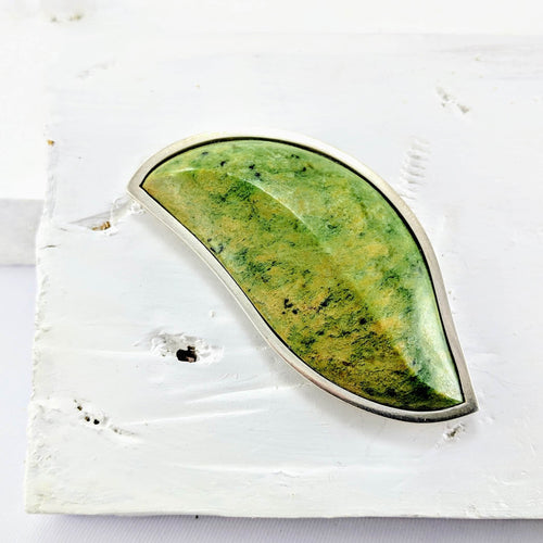 The beautiful pounamu leaf form in this brooch was carved by NZ artist Terence Turner. Jeweller Vaune Mason has crafted the unique sterling silver setting and back piece.