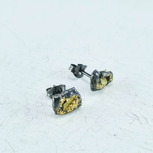 These irregular shaped stud earrings feature two yellow diamond slivers set in oxidised sterling silver with yellow gold fused to the surface. By Natalie Salisbury Jewellery.
