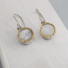 Load image into Gallery viewer, These classic drop earrings are hand crafted in sterling silver and mother of pearl shell. The rim on the front has a 22ct yellow gold trim so the earrings really catch the light. Made by David McLeod and available through Mason and Collins.

