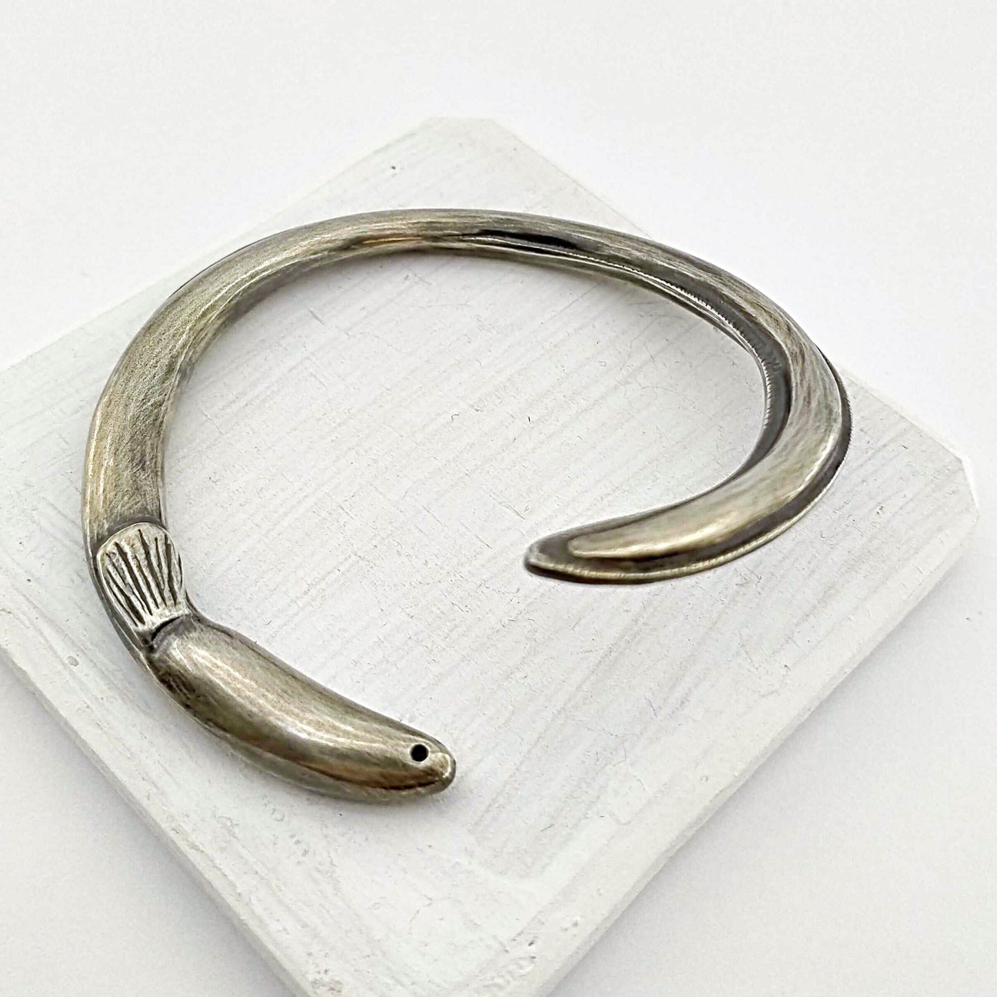 The tuna bracelet is handmade in NZ by The Wild Jewellery. Cast in solid sterling silver this bracelet represents the endangered long-finned eel that is native to Aotearoa NZ.