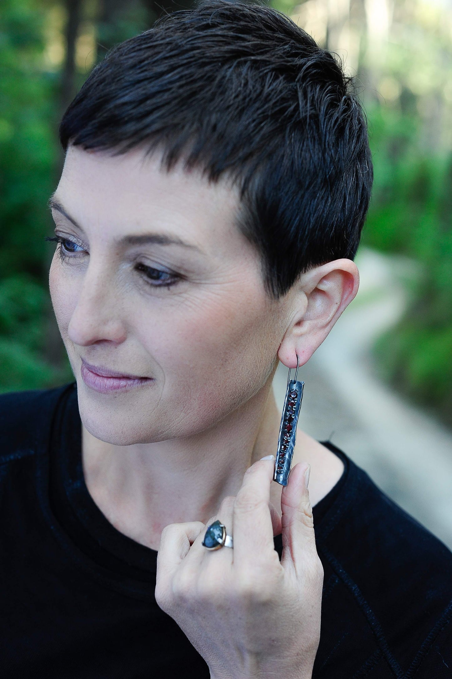 These unique earrings are hand crafted in oxidised sterling silver and set with graduated sizes of garnets. NZ jeweller Vaune Mason is known for her love of colourful gemstones and exciting setting style.
