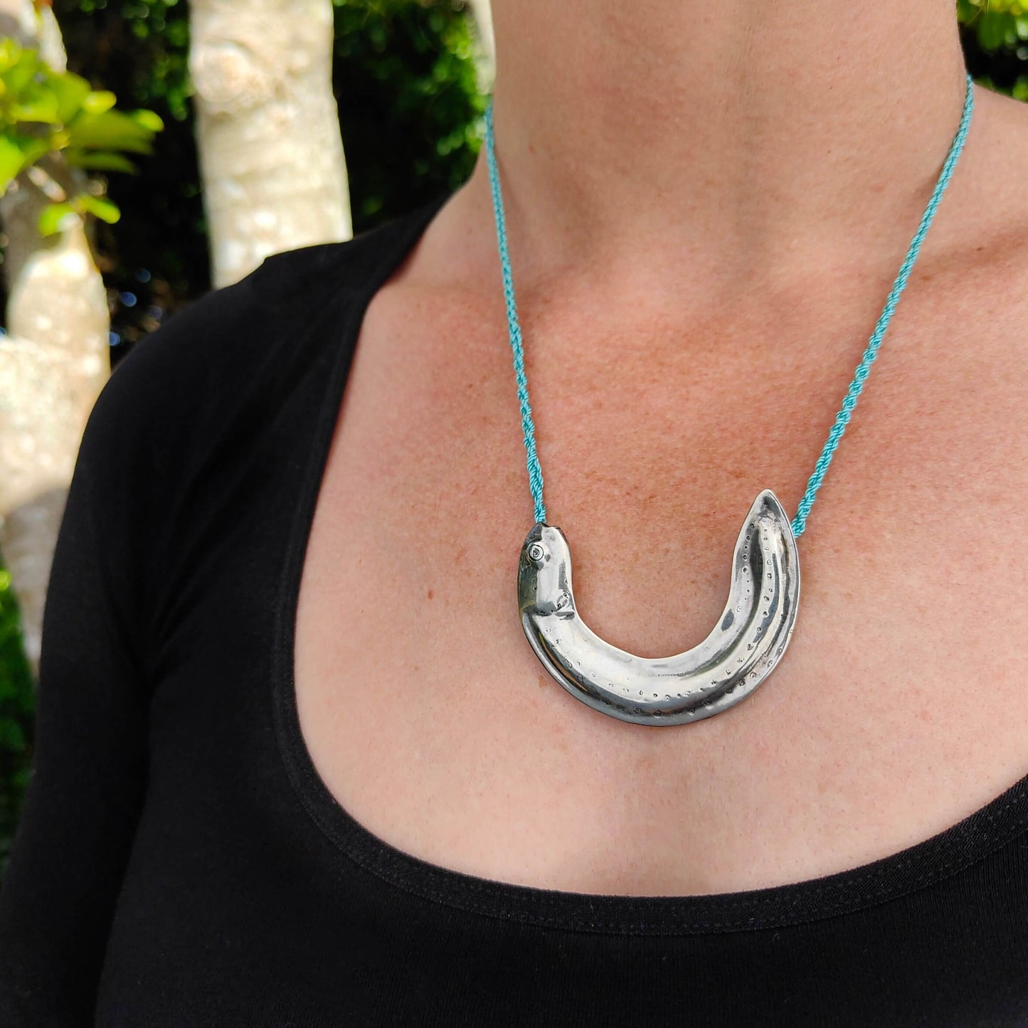 The silver Inanga  or Whitebait pendant from Vaune Mason is handcrafted in solid sterling silver and strung on a hand plaited nylon cord. Quality NZ jewellery at Mason & Collins.