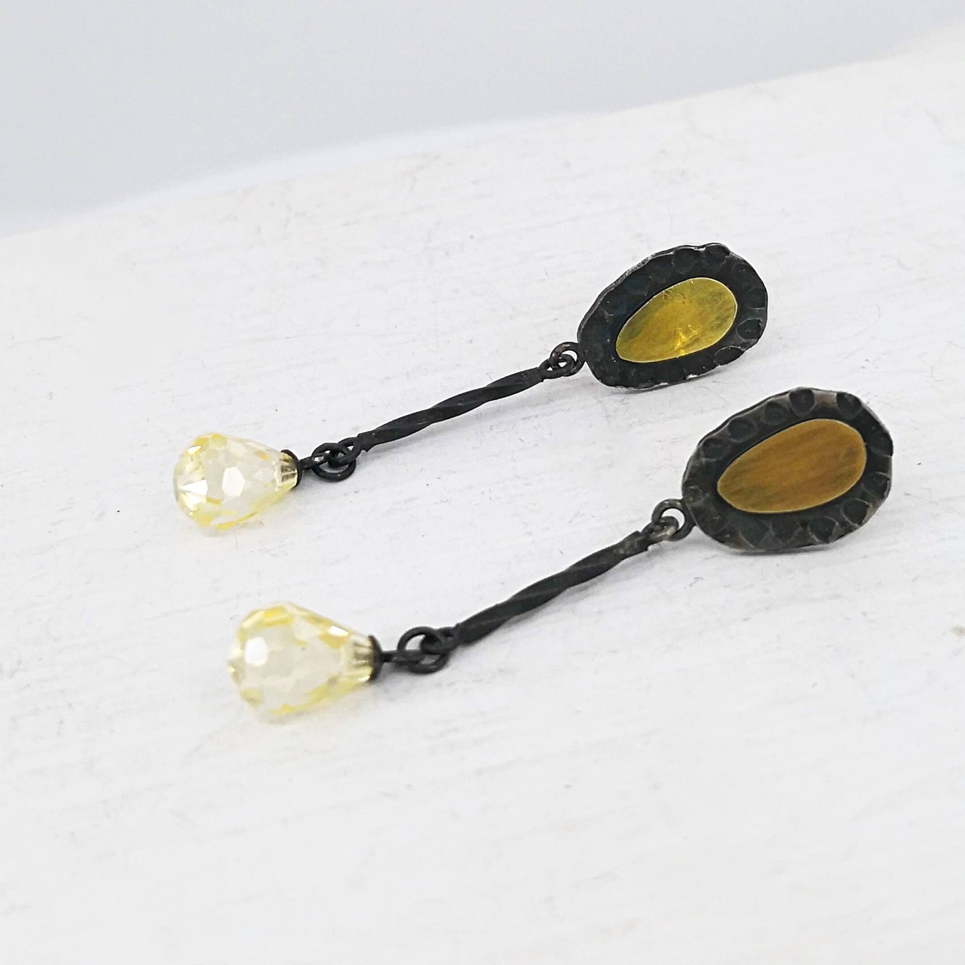 These delicate drop earrings are crafted in silver and 18 carat gold with delicate yellow cubic zirconia drops. By Vaune Mason.