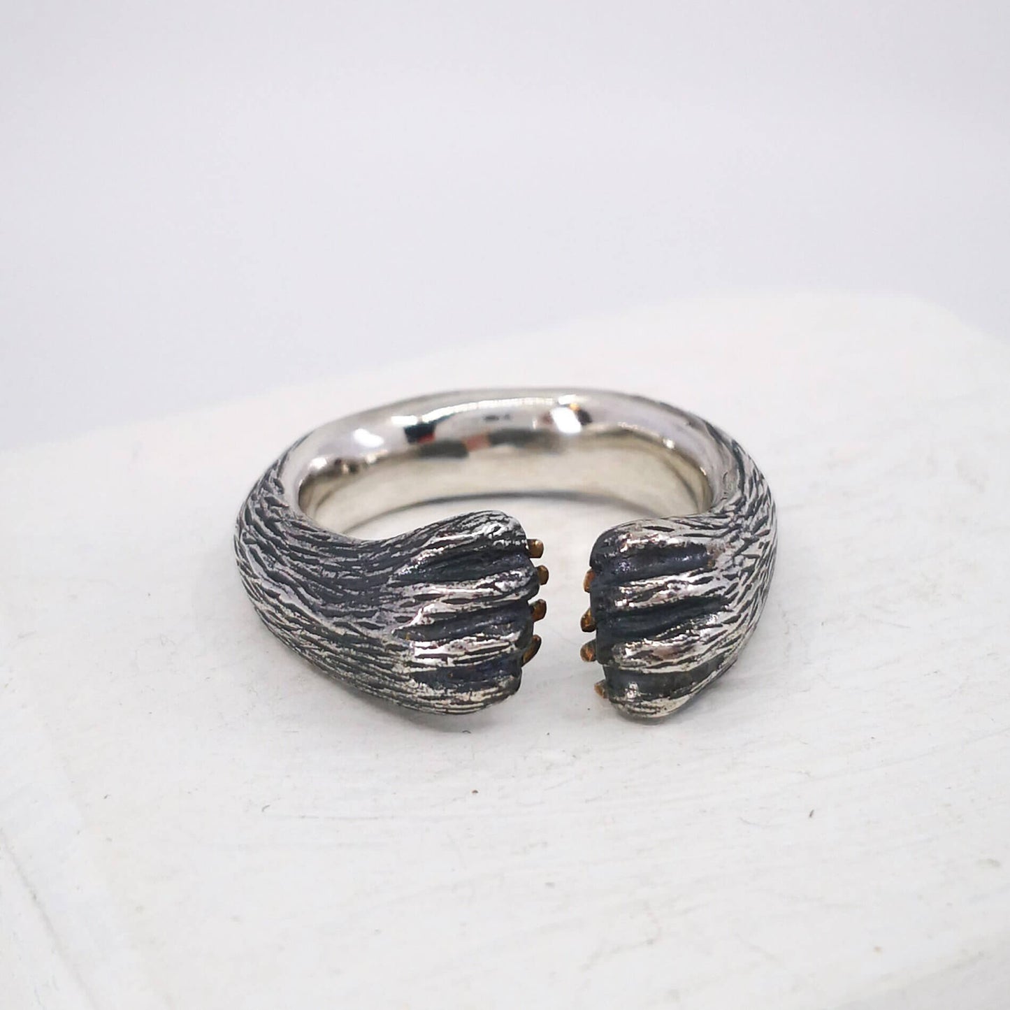 The Bear Hug Ring by NZ jeweller Vaune Mason is hand crafted in solid sterling silver with claws in 9ct yellow gold.