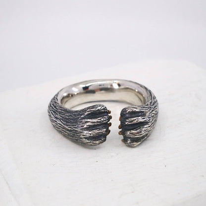 The Bear Hug Ring by NZ jeweller Vaune Mason is hand crafted in solid sterling silver with claws in 9ct yellow gold.