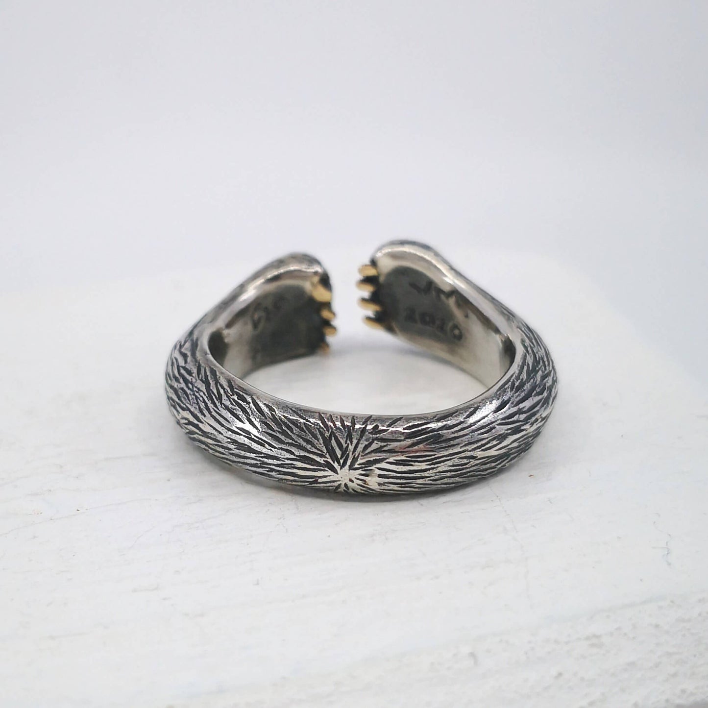 The Bear Hug Ring by NZ jeweller Vaune Mason is hand crafted in solid sterling silver with claws in 9ct yellow gold.