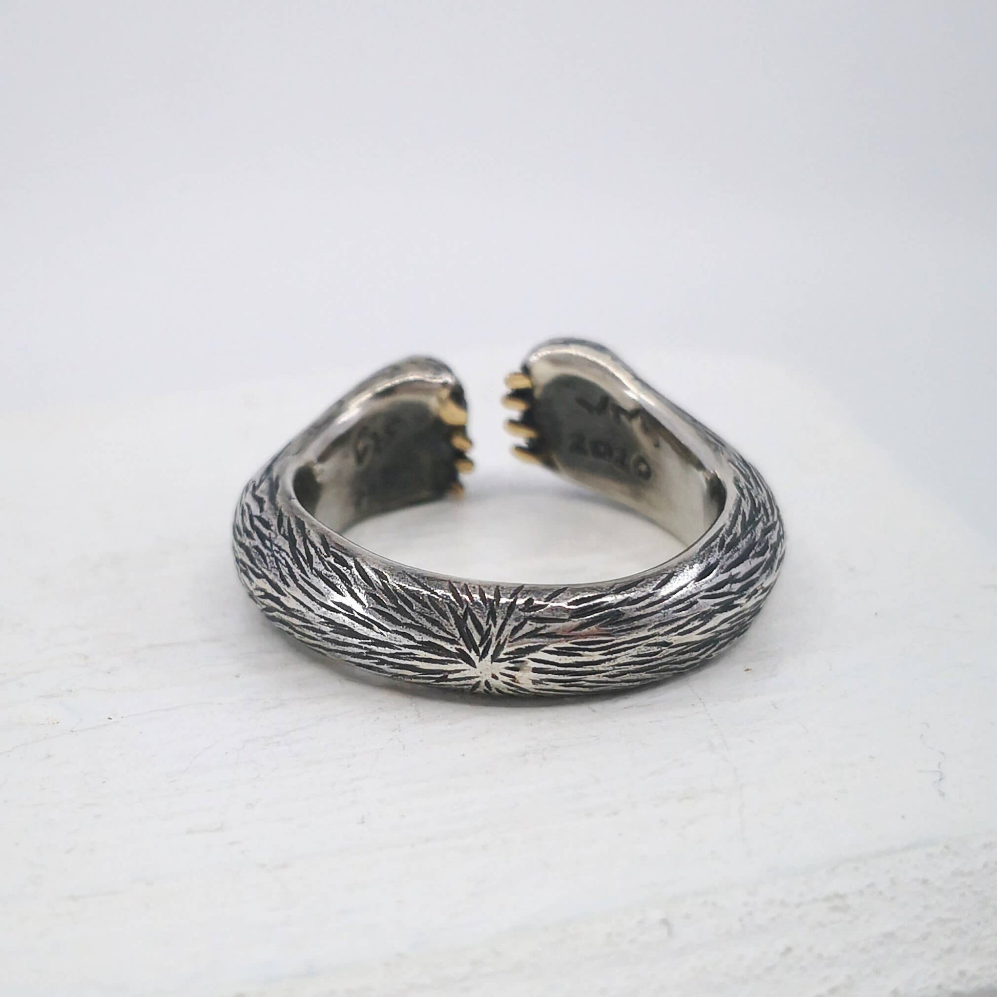 The Bear Hug Ring by NZ jeweller Vaune Mason is hand crafted in solid sterling silver with claws in 9ct yellow gold.