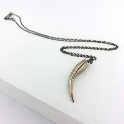 The Huia Beak charm pendant features a small curved beak pendant based on the distinctive curved bill of the now extinct Huia Bird. Handmade in NZ by The Wild Jewellery.