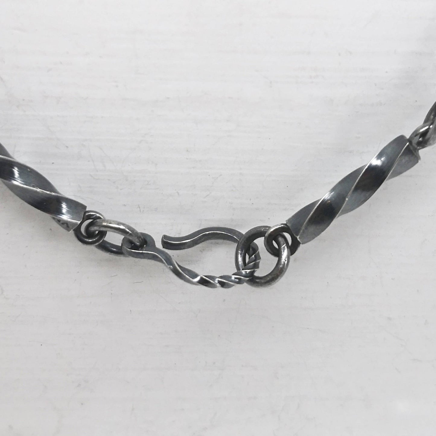 This statement necklace handcrafted by NZ jeweller Vaune Mason features hand-twisted silver chain links and a one-of-a-kind setting.