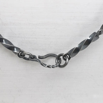 This statement necklace handcrafted by NZ jeweller Vaune Mason features hand-twisted silver chain links and a one-of-a-kind setting.