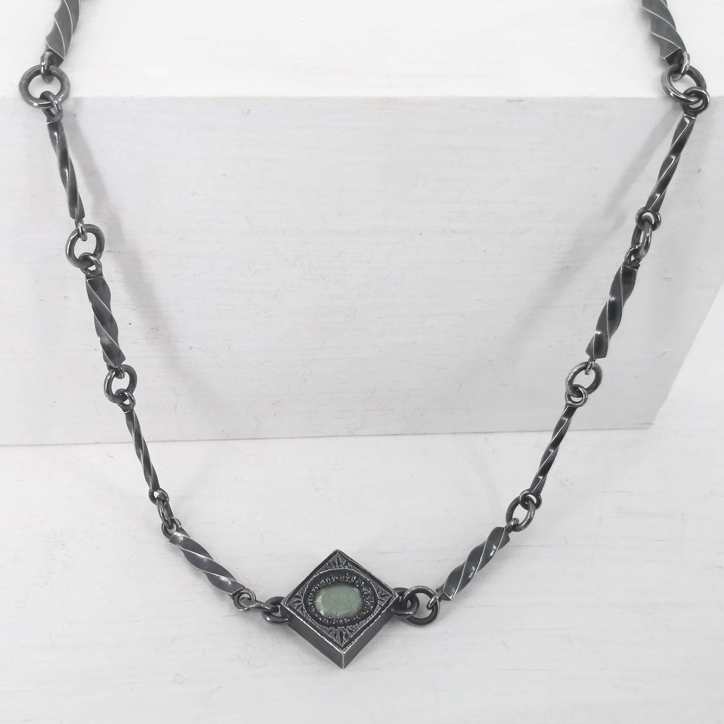 This statement necklace handcrafted by NZ jeweller Vaune Mason features hand-twisted silver chain links and a one-of-a-kind setting.