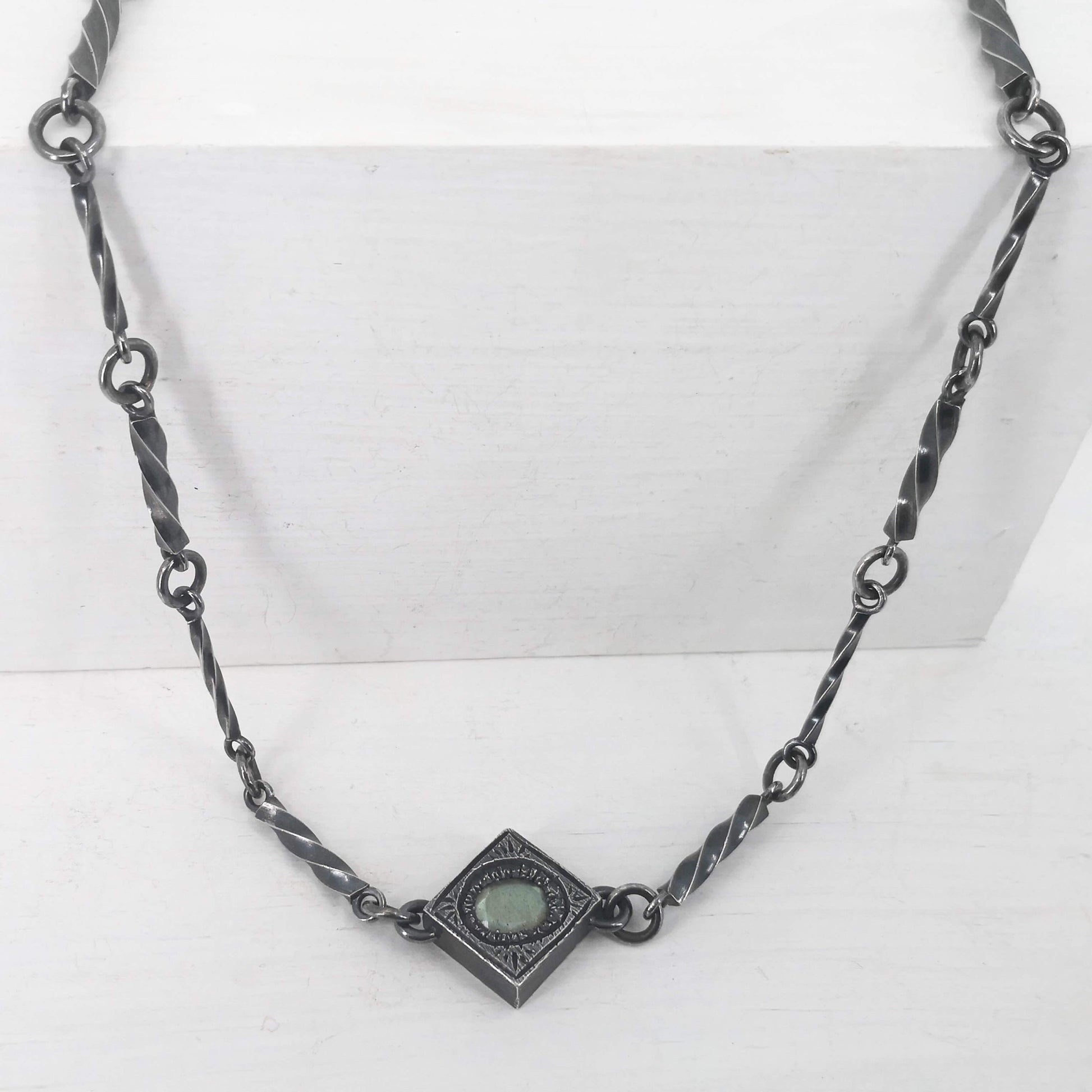 This statement necklace handcrafted by NZ jeweller Vaune Mason features hand-twisted silver chain links and a one-of-a-kind setting.