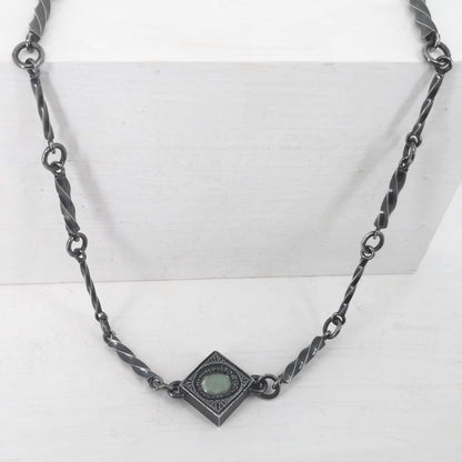 This statement necklace handcrafted by NZ jeweller Vaune Mason features hand-twisted silver chain links and a one-of-a-kind setting.