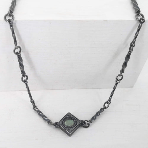 This statement necklace handcrafted by NZ jeweller Vaune Mason features hand-twisted silver chain links and a one-of-a-kind setting.