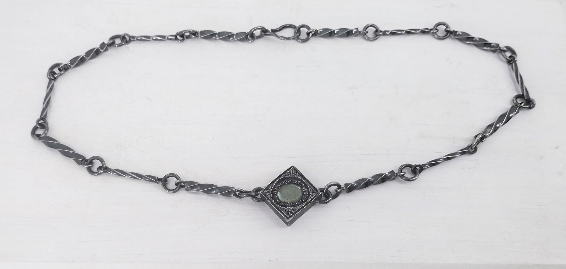 This statement necklace handcrafted by NZ jeweller Vaune Mason features hand-twisted silver chain links and a one-of-a-kind setting.