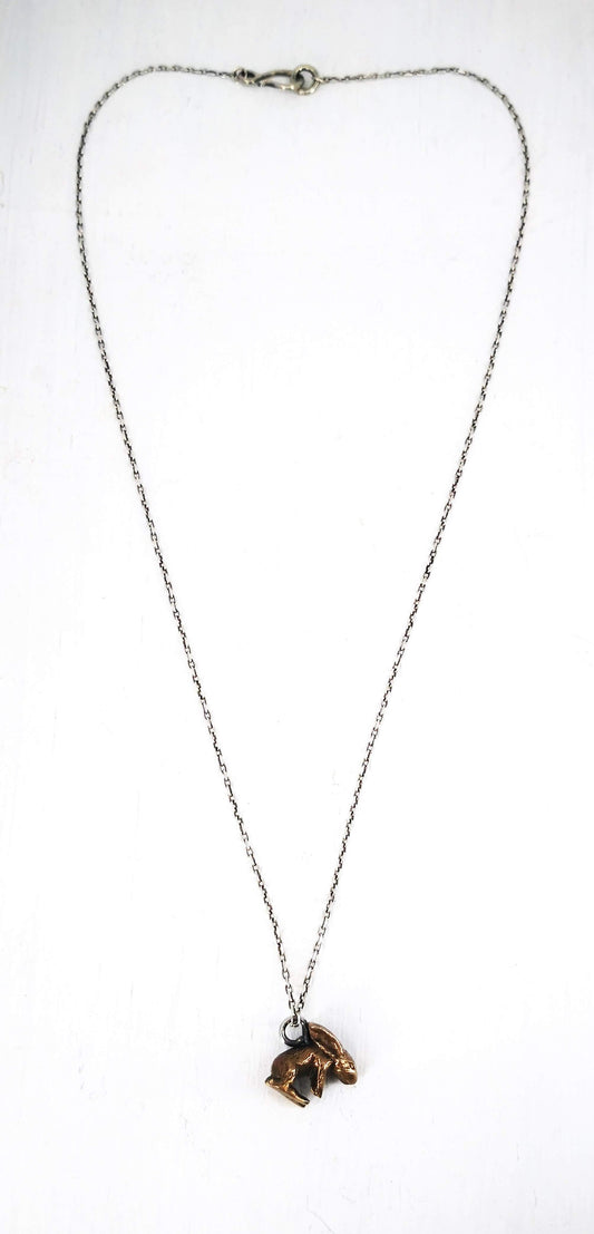 The Very Tiny Bunny necklace by Vaune Mason features a delicately carved bunny charm cast in warm bronze on a sterling silver chain.