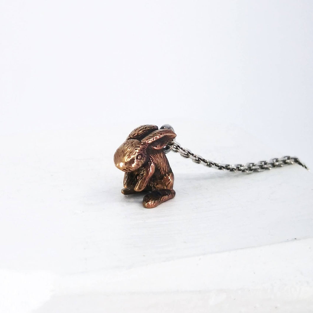 The Very Tiny Bunny necklace by Vaune Mason features a delicately carved bunny charm cast in warm bronze on a sterling silver chain.